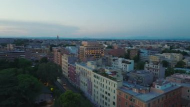 Aydınlatılmış Soho evinin kaydırak ve tava görüntüsü. Alacakaranlıkta şehir merkezindeki binaların üzerinden uç. Roma, İtalya.
