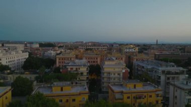 Şehir merkezindeki binaların üzerinden uçuyor. Alacakaranlık 'ta büyük bir şehirde büyük konutlarda apartman binaları. Roma, İtalya.