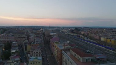 Merkez tren istasyonundaki ve etrafındaki binalardaki tren raylarının üzerinden uçun. Renkli alacakaranlık gökyüzü. Roma, İtalya.