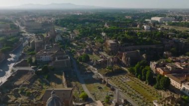 Şehir merkezindeki yerleşim binalarıyla çevrili caddenin üzerinde uçuyorlar. Metropolis bulutlu bir günde. Roma, İtalya.