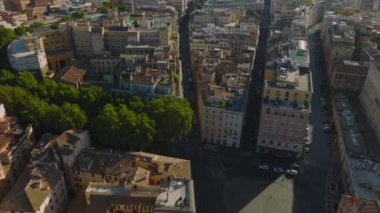Şehir merkezindeki eski çok katlı konutların üzerinde alçak uçuş. Renkli cepheler sabah güneşiyle aydınlanır. Roma, İtalya.