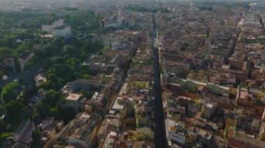 Caddelerin üzerinde ve şehirde binalar uçuyor. Tarihi şehir merkezindeki manzaralar. Sahne sabah güneşiyle aydınlandı. Roma, İtalya.