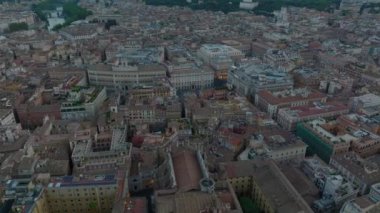 Şehirdeki binaların üzerinden ileriye doğru uçuyor. Alacakaranlıktaki tarihi evler ve saraylar. Roma, İtalya.