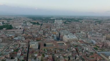 Şehir merkezindeki tarihi binalar, şehir simgeleri ve turistik yerler üzerinde ilerliyorlar. Alacakaranlıkta Vittoriano anıtına doğru gidiyor. Roma, İtalya.