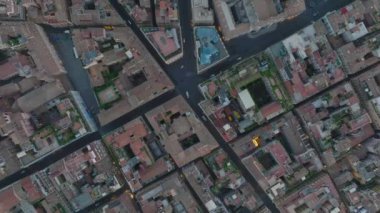 Alacakaranlıkta şehir merkezindeki tarihi binalar arasında dar caddelerde giden arabaların yukarıdan çekimleri. Roma, İtalya.