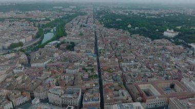Bulutlu bir günde büyük şehrin havadan panoramik görüntüsü. Yeşil ağaçlar ve binicilik kompleksiyle parkın üzerinde uçuyor. Roma, İtalya.