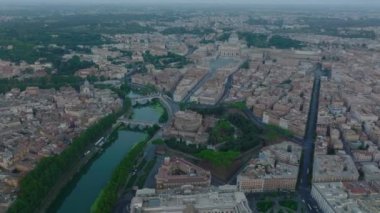Gündoğumunda şehir merkezinin caddesindeki apartman dairelerinin tepesinde forvetler uçar. Parlak gökyüzüne karşı kulenin silueti ortaya çıkıyor. Roma, İtalya.