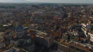 San Carlo al Corso 'nun geniş kubbesinin uzaktan kaydırağı ve pan görüntüsü. Şehir merkezinde çatıların üstünde alçak uçuş. Roma, İtalya.