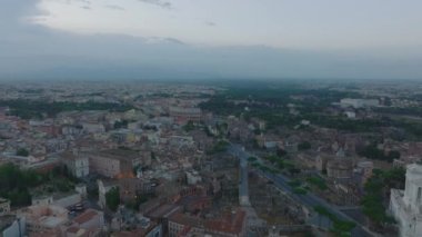 Tren istasyonundaki platformun ve etrafındaki binaların parlak sabah güneşiyle aydınlanan görüntüsü. Meşhur antik Kolezyum 'u ortaya çıkarmak için eğil. Roma, İtalya.