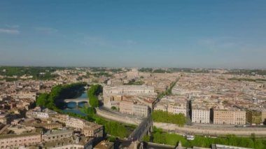 Şehirdeki eski binaların hava sineması görüntüleri. Tiber nehri boyunca yeşil ağaçlar ortada bükülüyor. Roma, İtalya.