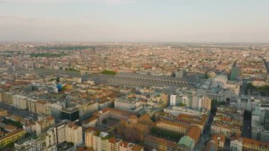 İleri uçuşu Metropolis 'in altın saatinde. Tarihi binaları olan tren istasyonunun havadan görünüşü. Milano, İtalya