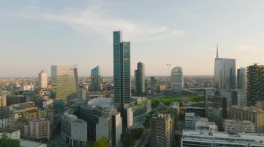 Şehirde altın saatinde modern yüksek binalar. Şehir merkezindeki evlerin tersten ortaya çıkarılması. Milano, İtalya