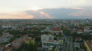 Gün batımında Metropolis 'teki şehir gelişiminin hava panoramik görüntüleri. Güneş gökyüzünde bulutların arkasında saklanıyor. Milano, İtalya