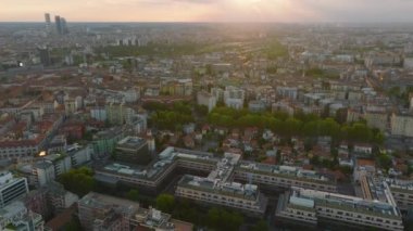 Yükselen güneşe karşı şehrin havadan çekilmiş görüntüleri. Şehir merkezindeki konut ve ofis binaları. Milano, İtalya.