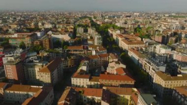 İleri uçaklar sabah yerleşim bölgesinin üzerinde uçar. Parlak gün ışığıyla aydınlatılan çok katlı apartmanlar. Milano, İtalya.
