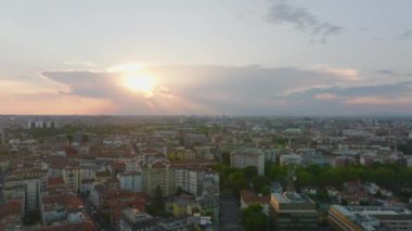 Güneşin batmasına karşı şehir merkezinin hava panoramik görüntüleri. Kırmızı çatılı çok katlı evler. Milano, İtalya.
