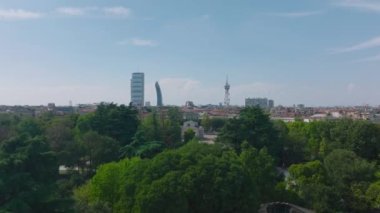 Forwardlar parktaki ağaçların üzerinden uçarak Arco della Pace 'in tarihi simgesini ortaya çıkarıyor. Şehir Hayatı konumu içinde modern tasarım ofis kuleleri. Milano, İtalya.