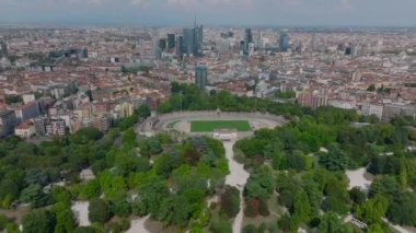 Kamu parkındaki ağaçlarla çevrili Atletik stadyum Arena Civica Gianni Brera 'nın kaydırak ve pan görüntüleri. Şehrin panoramik manzarası. Milano, İtalya.