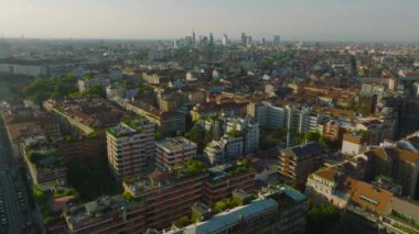 Altın saat 'de yerleşim yerinin üzerinden uç. Uzaktaki modern yüksek katlı ofis binaları olan şehir manzarası. Milano, İtalya.