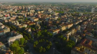 Şehir merkezindeki çok katlı apartmanların üzerinden uç. Sahne, parlak alçak güneş tarafından aydınlatıldı. Milano, İtalya.