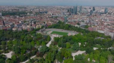 Metropolün havadan panoramik görüntüsü. Atletik stadyumu ve şehir merkezi gökdelenleri olan halka açık bir park. Milano, İtalya.