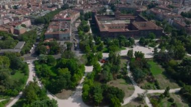 Parktaki yeşil bitki örtüsünün yüksek açılı görüntüsü. Eğim, Sforzesco kalesinin tarihi kompleksini ve Metropolis 'in panoramik manzarasını gözler önüne seriyor. Milano, İtalya.