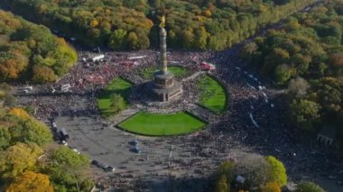Grosser Stern Meydanı 'ndaki Siegessaule' nin hava kaydırak ve pan görüntüleri İranlı protestocular Berlin, Almanya 'yı destekleyen insanlarla dolu..
