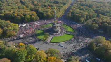 Meydandaki protestocuların hava görüntüsü. Yukarı doğru eğildiğinde şehrin arka planındaki binalar ortaya çıkıyor. Berlin, Almanya.