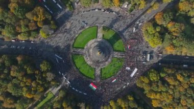 İranlılar meydanda protesto yapıyor. Merkezinde büyük bir döner kavşak ve zafer sütunuyla simetrik meydanın yükselen görüntüsü. Berlin, Almanya.