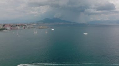 Sahil boyunca geniş yelkenli ve yat manzarası var. Tarihi şato Castel dellOvo ve Vesuvius Dağı volkanının silueti. Napoli, İtalya.