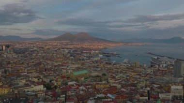 Gün batımında şehrin panoramik görüntüsü. Görkemli Vezüv Dağı, alçak güneş tarafından aydınlatılıyor. Napoli, İtalya.