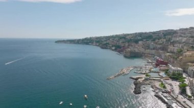 Turist beldesindeki deniz kıyısında ilerliyorlar. Posillipo ilçesindeki lüks tarihi binaların panoramik manzarası. Napoli, İtalya.