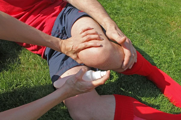 Terapeuta atendiendo a deportista lesionado — Foto de Stock