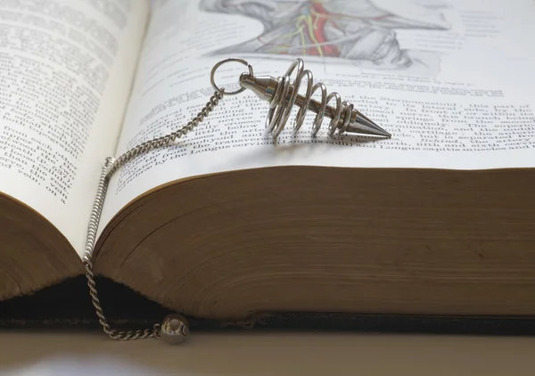 Dowsing con un viejo libro médico —  Fotos de Stock