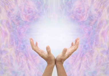 Faith Healer sending energy distant healing - female cupped hands reaching up to a  white light energy orb against a lilac and pink symmetrical ethereal  pattern background with copy space for messages                                