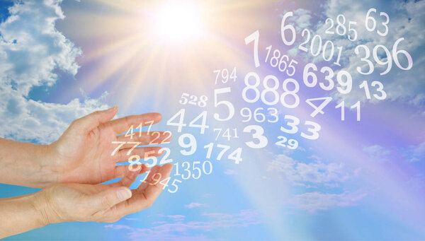 Consult with a Numerologist about your Future - female hands with numbers flowing outwards against a bright blue sky and sunburst background with copy space