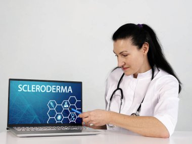  Ekrandaki ScLERODERMA yazıtları. Siyah dizüstü bilgisayarı tutan Hematolog elleri kapatın.
