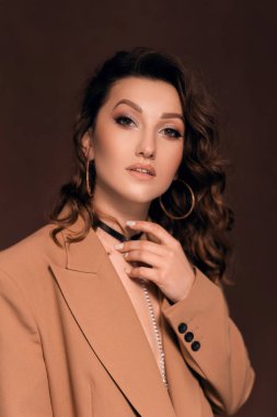 Gri ceketli, boynunda boyunluğu olan güzel bir kadın.