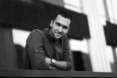 Çalıntı ellerle tıraşsız kılları olan yakışıklı bir adamın siyah beyaz portresi.