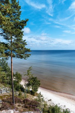 Evazi kayalıkları ya da Letonya 'daki Baltık Denizi kıyısında güneşli bir yaz günü. Mavi gökyüzü, mavi deniz, beyaz kum.