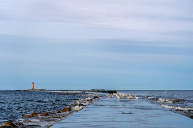 Mangalsala ya da doğu rıhtımında kış fırtınasının sonunda parlak turuncu bir deniz feneri vardı. Letonya 'nın Riga kentindeki rıhtımdan birinde Daugava Nehri Baltık Denizi' ne akar..