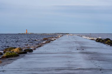 Mangalsala ya da doğu rıhtımında kış fırtınasının sonunda parlak turuncu bir deniz feneri vardı. Letonya 'nın Riga kentindeki rıhtımdan birinde Daugava Nehri Baltık Denizi' ne akar..