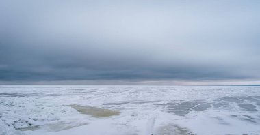 Letonya 'da bulutlu kış gününde donmuş Baltık Denizi.
