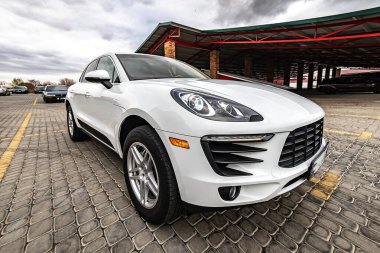 Compact white executive car, with business car, large chrome grille.