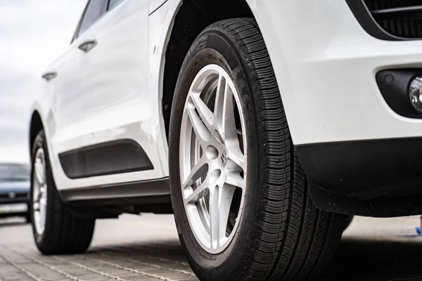 Compact white executive car, with business car, large chrome grille.