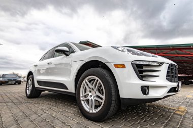 Compact white executive car, with business car, large chrome grille.