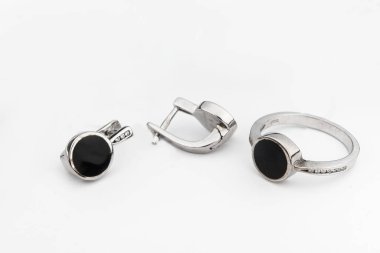 Gümüş mücevher seti ve taştan beyaz arka planı olan gümüş küpeler. Gümüş mücevher koleksiyonu