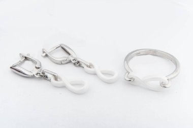 Gümüş mücevher seti ve taştan beyaz arka planı olan gümüş küpeler. Gümüş mücevher koleksiyonu