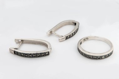 Gümüş mücevher seti ve taştan beyaz arka planı olan gümüş küpeler. Gümüş mücevher koleksiyonu