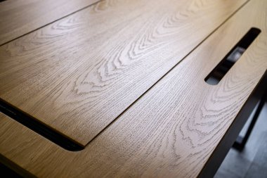 Karanlık odada boş ahşap masa.